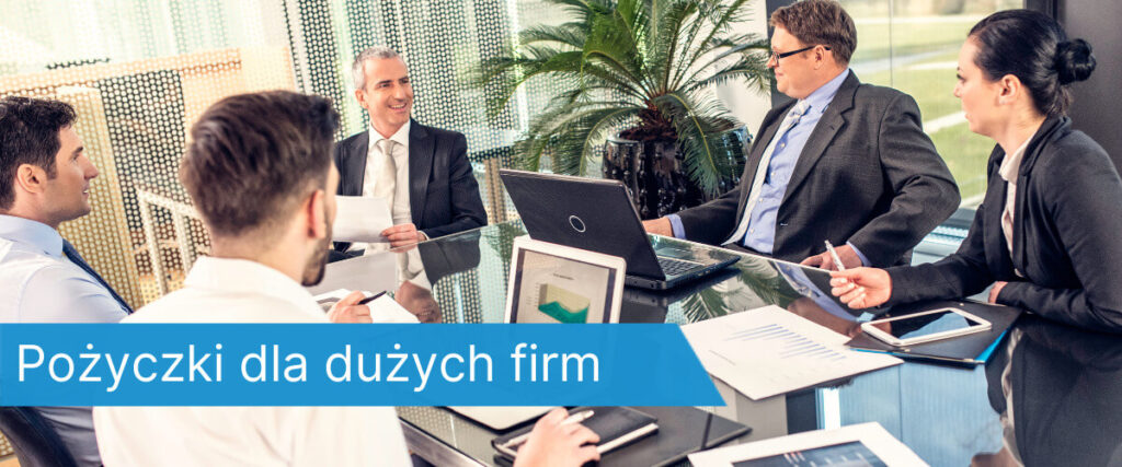 Pięciu profesjonalnie ubranych pracowników siedzi przy szklanym stole, prowadząc rozmowę biznesową z laptopami i dokumentami